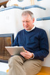 Foto: Senior at home in front of fireplace Senior at home in front of fireplace