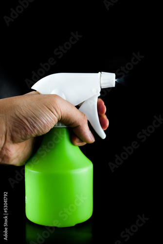 Photo: Green plastic sprayer isolated on black background Green plastic sprayer isolated on black background