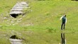 child throws a stone in the pond