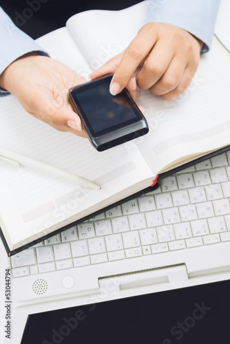 Photo: Business woman hands with smart phone, work place Business woman hands with smart phone, work place