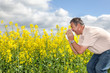 Man with hay fever on blooming rapeseed field