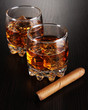 Brandy glasses with ice on wooden background