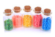 Foto: Different colorful beads in bottles isolated on white Different colorful beads in bottles isolated on white