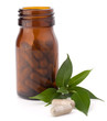 Herbal drug capsules in brown glass bottle. Alternative medicine