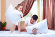 positive father and son having fun at home, pillow fight