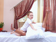 positive father and son having fun at home, pillow fight