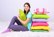 Foto: Beautiful young girl with pillows in room Beautiful young girl with pillows in room