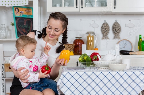 Photo: Mother with baby in kitchen. Mother with baby in kitchen.