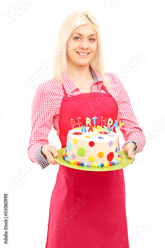 Photo: Blond female chef in apron holding a delicious cake Blond female chef in apron holding a delicious cake