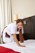 Putzfrau reinigt Schlafzimmer im Hotel