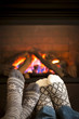 Feet warming by fireplace