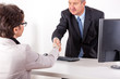 Businessman in office ranges woman's hand