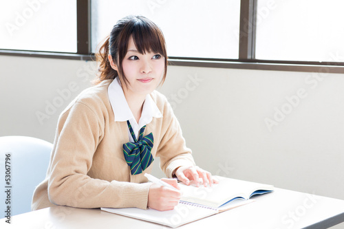 Photo: a young asian school girl studying a young asian school girl studying