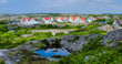Some houses on an island with rocks and a water puddle