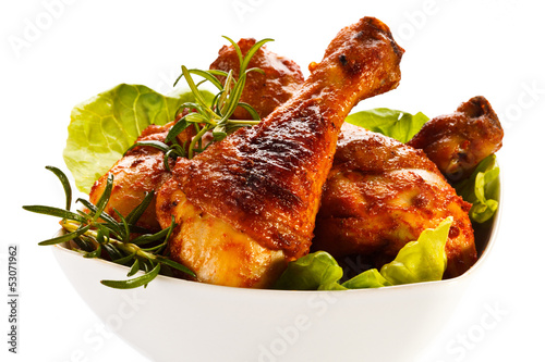 Photo: Grilled chicken legs and vegetables on white background Grilled chicken legs and vegetables on white background