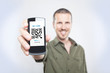 Youn man showing the phone with qr code