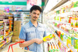 man in a supermarket buying a bottle of juice
