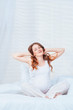 Pregnant woman sit on bed