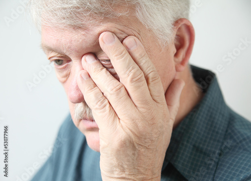 Photo: tired man rubbing his eye tired man rubbing his eye