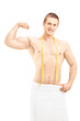 Muscular man showing his biceps and posing with measuring tape