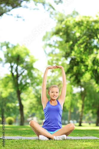 Photo: Female stretching arm in a park Female stretching arm in a park