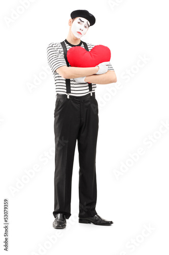Photo: Full length portrait of a sad mime artist holding a red heart Full length portrait of a sad mime artist holding a red heart