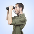 young man looking through binoculars, surprise face expression