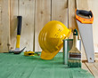 green wood floor with a brush, paint, saw and yellow helmet