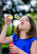 beautiful child blowing bubbles