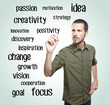 Young casual man writing keywords on glass board with marker