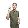Young casual man writing something on glass board with marker