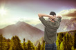 young man on top of the mountain, realxing and enjoying the view