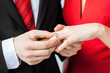man putting  wedding ring on woman hand