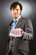 Young  businessman showing euro banknotes and winking