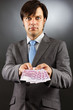 Young businessman showing euro banknotes