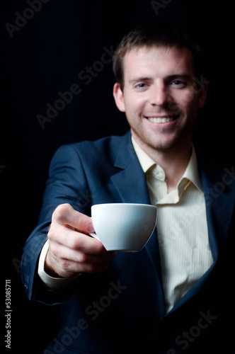 Photo: Business man giving you a coffee cup Business man giving you a coffee cup