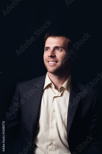 Photo: Low-key portrait of a smiling business man Low-key portrait of a smiling business man