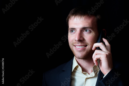 Photo: Portrait of a smiling business man talking mobile Portrait of a smiling business man talking mobile