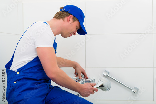 Photo: Klempner oder Installateur bei Arbeit im Bad Klempner oder Installateur bei Arbeit im Bad