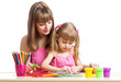 Mother and kid girl draw and cut together