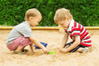 Foto: Two kids friends playing with sand outdoor. Summer season Two kids friends playing with sand outdoor. Summer season