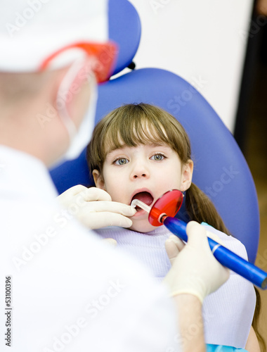 Photo: little girl with open mouth receiving dental filling little girl with open mouth receiving dental filling