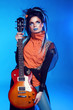 Rock girl posing with electric guitar isolated on blue backgroun