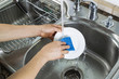 Photo: Female hands washing single white dinner plate Female hands washing single white dinner plate
