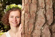 Blumenmädchen hinter Baum