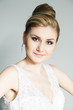 Studio portrait of young bride in white dress