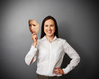 Photo: woman hiding her good mood under sad mask woman hiding her good mood under sad mask