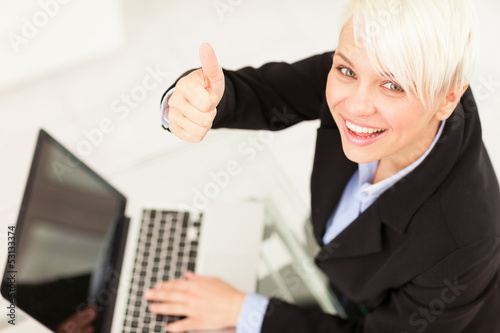 Photo: Businesswoman making positive thumb gesture Businesswoman making positive thumb gesture