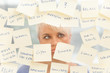 Overworked woman in front of a window full with notes