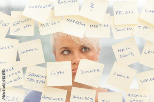 Photo: Overworked woman in front of a window full with notes Overworked woman in front of a window full with notes